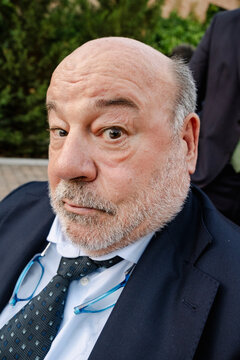 Older man in suit raising eyebrow at real wedding reception