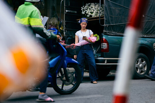 Woman Checks Phone on Busy Street
