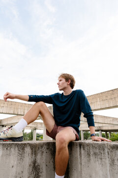 Full-body shot highlighting an athletic man posing in activewear