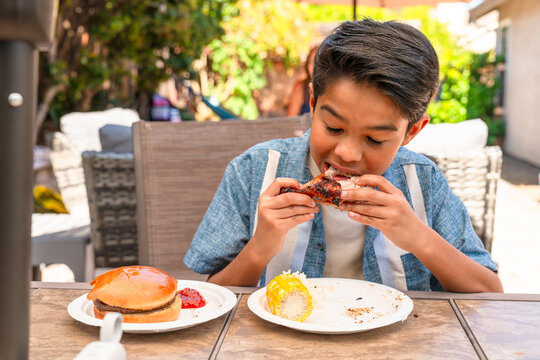 boy eating backyard bbq burger