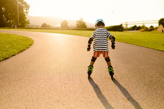 Child Learning to Roller Skate at Sunset