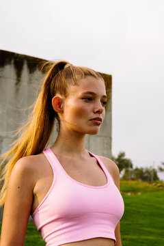 Female athlete in sportswear posing in a sunny city park