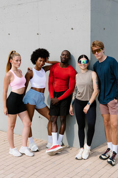 Confident athletes in empowered poses looking at camera in a park