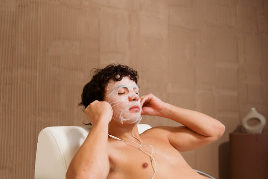 Man Relaxes With a Face Mask and Headphones in a Wellness Center