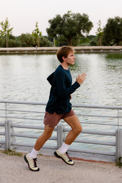 High-performance athlete training alone near a natural lake