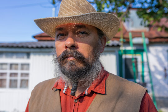 Portrait of a bearded man in a hat.