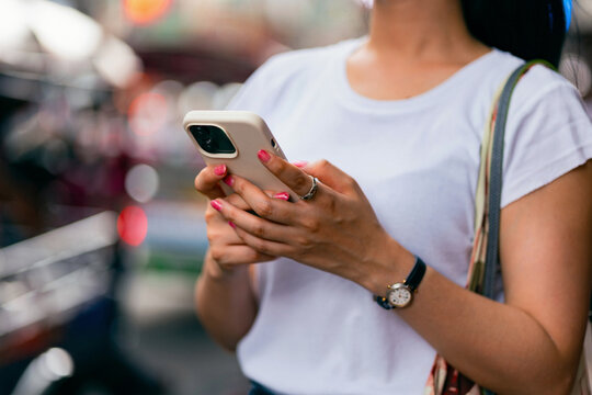 Young Woman Using Smartphone Outdoors in Urban Street