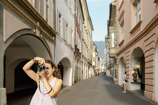 Woman taking photo on Italian old town street in summer