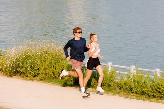 Full-body shot of an active couple enjoying a morning jog