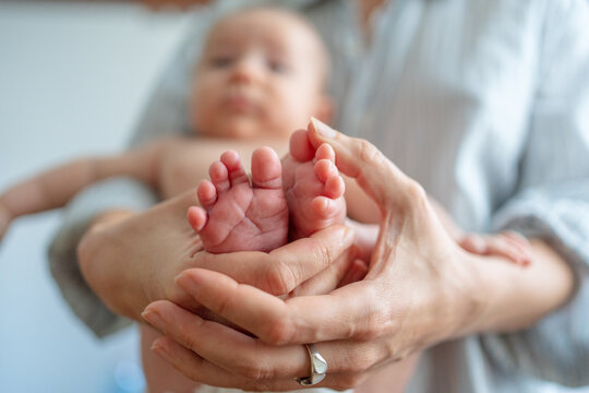 Parent Holds Baby&rsquo;s Feet in Soft Hands at Home in Daytime