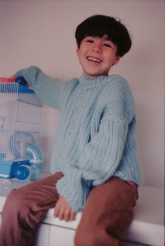 Happy smiling young boy in blue knit sweater on 35mm film