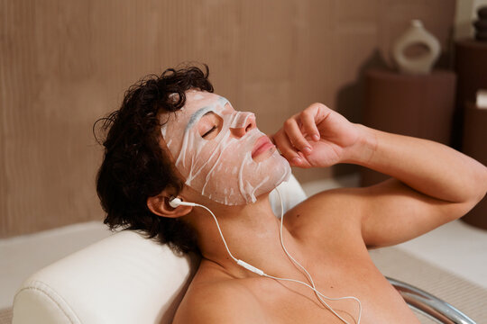 Woman Enjoys Facial Mask While Listening to Music Indoors