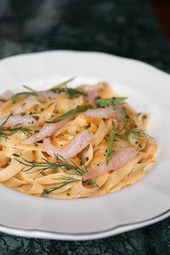 Dish of Pasta With Shrimp Served on a White Plate