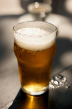 Cold Beer Served in a Clear Glass on a Sunny Table