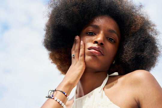 Young Person Poses With Hand on Face Outdoors During Daytime