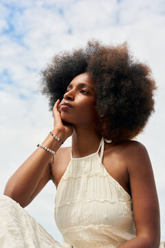 Woman With Curly Hair Posing Outdoors on a Sunny Day