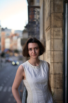 Woman Standing on a Balcony in a City With Buildings Behind