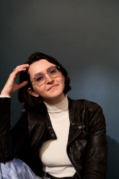 Person Sitting Against a Dark Wall With Hand on Head
