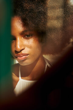 Portrait of a Woman With Curly Hair Near a Window