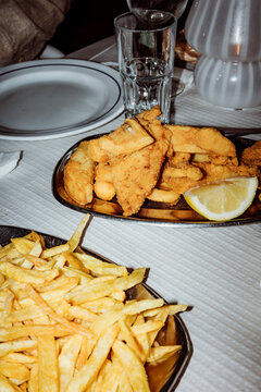 Fried Fish and Chips Served on a Plate With Lemon Slice