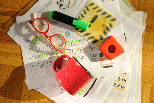Calendar with business appointments and deadlines,pens,and paperwork on  messy workplace. Business concept beat the clock, overworked, stress.