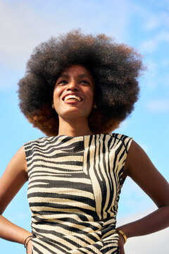 Woman With Large Afro Hairstyle Smiles in Outdoor Setting