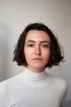 Woman With Curly Hair Wearing a White Top in Indoor Setting