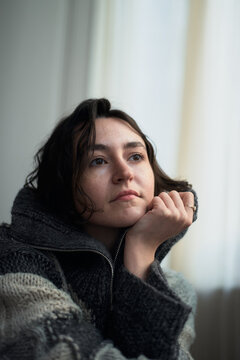 Thoughtful Woman Looks out a Window in a Cozy Space