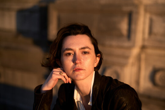 Person Sitting Outside in Evening Light With a Thoughtful Expression