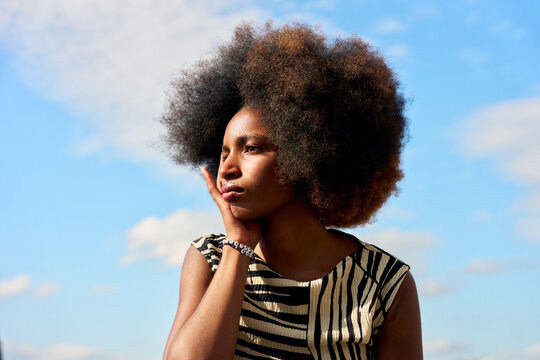 Woman Looking Thoughtfully at the Sky in a City Environment