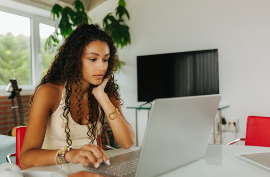 Woman Working On Laptop In Loft Apartment