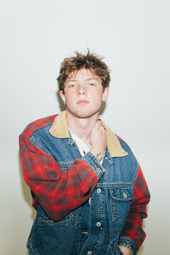 Young man in denim jacket with direct flash indoors