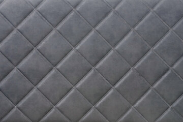 Obraz premium Gray quilted leather upholstery with diamond stitching and soft padded surface. Decorative textile pattern furniture material interior design luxury texture seating detail and neutral background.