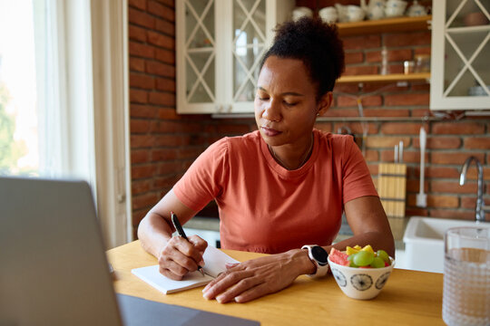 Woman working remotely, sitting in the kitchen