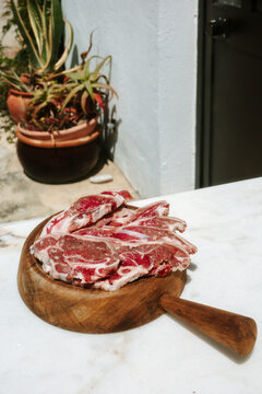 Fresh Meat Cuts on a Wooden Board Outside a Kitchen