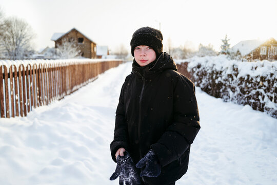Winter Joy as a Child Explores a Snowy Path Near a Cozy Home