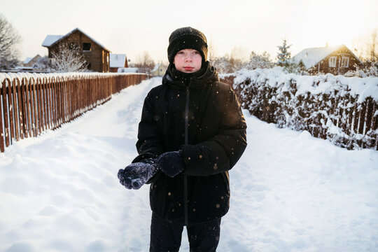Child Enjoying a Snowy Day While Standing in a Quiet Neighborhood