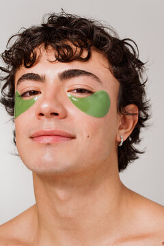 Man Applying Green Eye Patches at Home