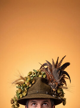 Man wearing traditional Oktoberfest hat with hops and feathers