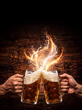 Two hands clinking beer mugs with magical fire splash