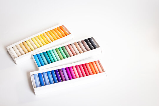 Set of soft pastel crayons in various shades in open white box, close up. Pastel crayons, set, shades, box, open, white, close up.
