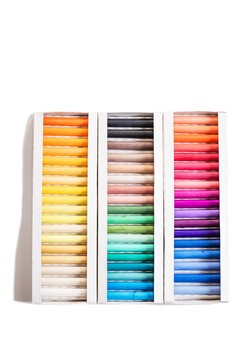 Set of soft pastel crayons in various shades in open white box, close up. Pastel crayons, set, shades, box, open, white, close up.
