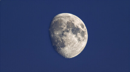 Obraz premium Detailed close-up of the bright waxing gibbous moon against a dark blue night sky with astronomy celestial universe satellite astrophotography brightness stargazing exploration