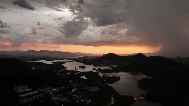 Dusk landscape featuring lake and mountain silhouettes against sunset sky