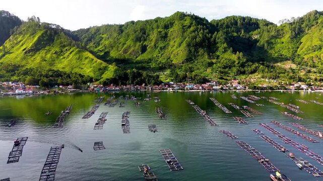 Scenic aerial landscape of Lake Toba with a lakeside village and green mountains in Indonesia