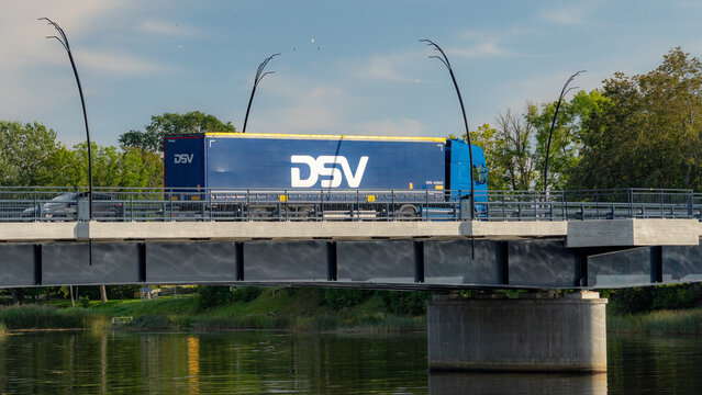 SALACGRIVA, LATVIA - AUGUST 28, 2026: DSV logistics semi-trailer truck crossing a bridge in Salacgriva, illustrating international road freight transport and European logistics.