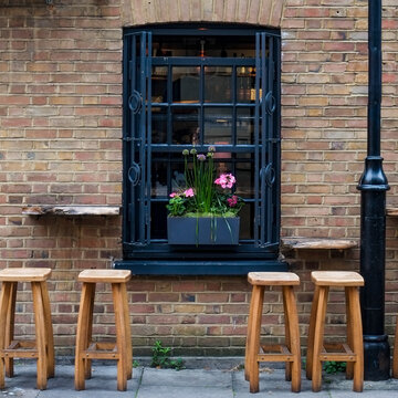 Window with flower box and wooden stools below