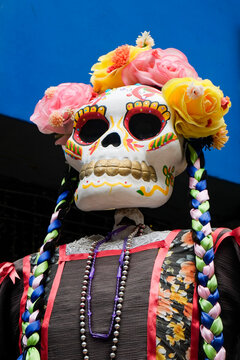 Decorated paper mache skull figure with flowers