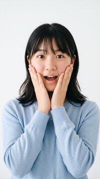 Young girl with wide eyes and open mouth expressing surprise and shock, white background