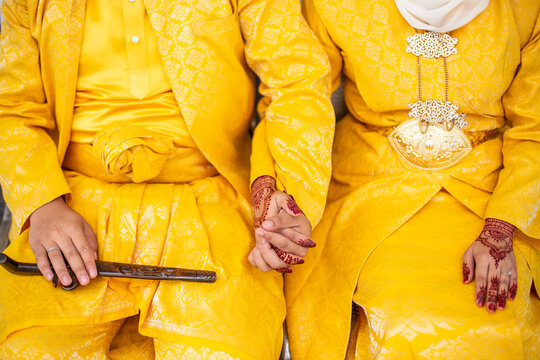 Malay Couple in Yellow Songket Holding Hands